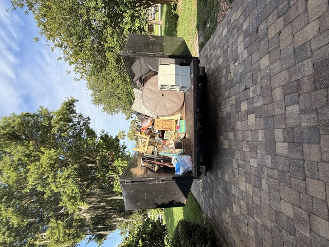 A hauling trailer loaded with furniture and household belongings during an estate cleanout.